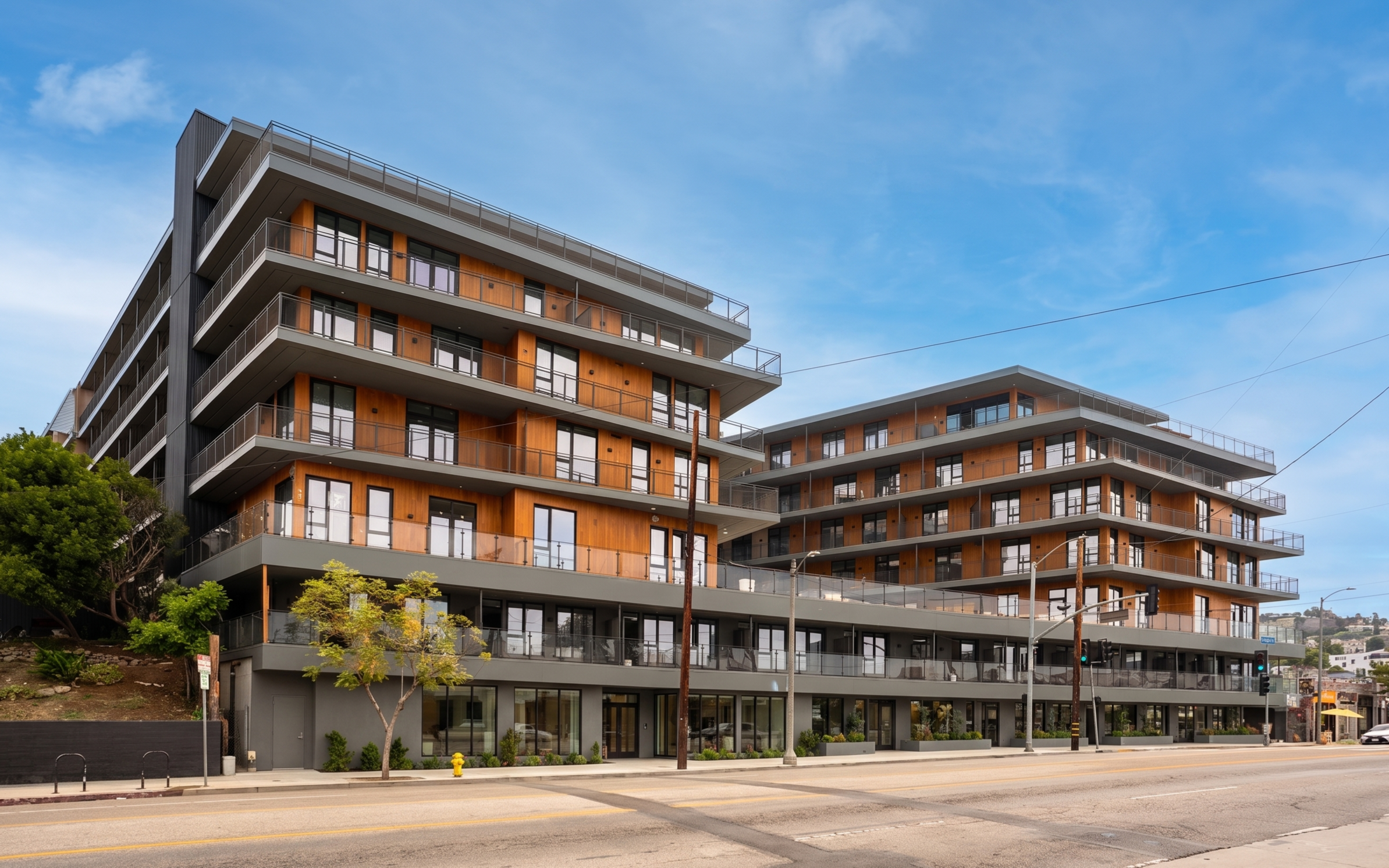 A modern multi-story building with balconies and large windows.